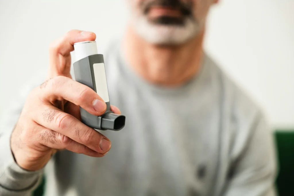 A man holding an asthma pump.