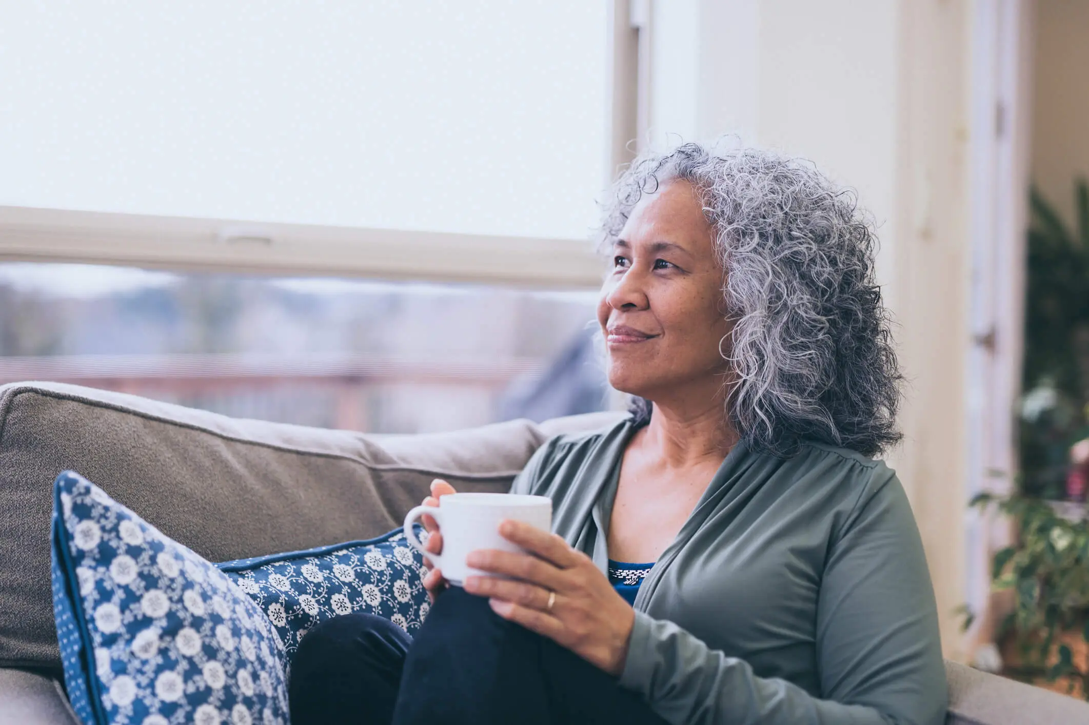 woman sitting on her couch with tea