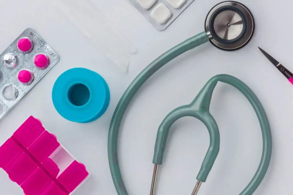 Stethoscope, pills and gauze on a table.