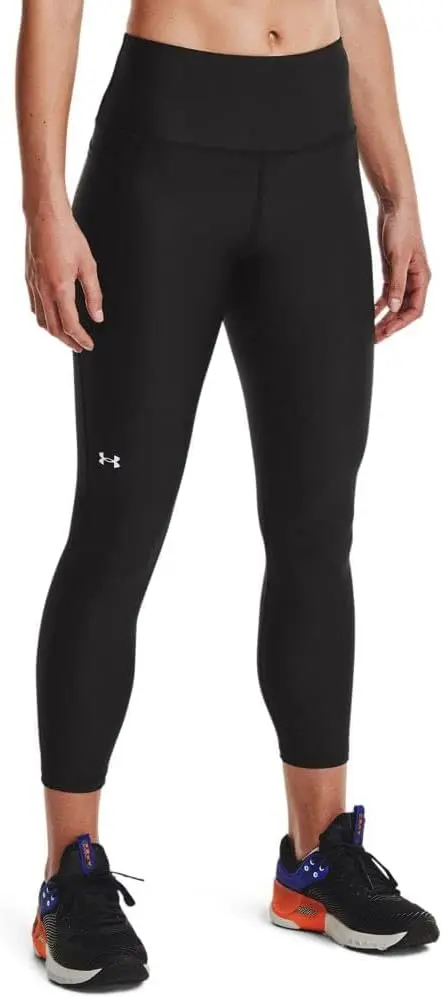 A person stands in multi-colored shoes while wearing calf-length black workout leggings.