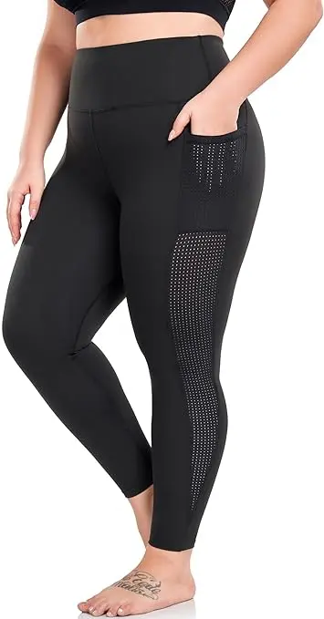 A woman stands on her toes while wearing black leggings with black mesh down the side of the leg. One hand is in her mesh pocket.