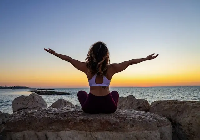 A woman stretching on a rock