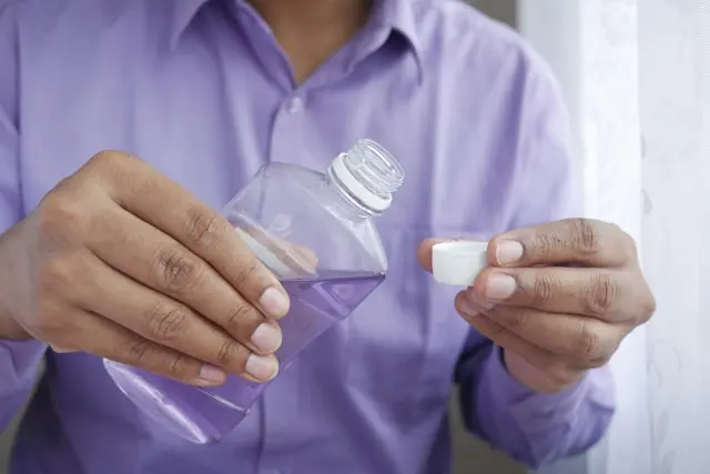 A woman holding mouthwash