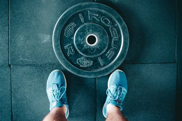 A weightlifter's shoes next to a weight