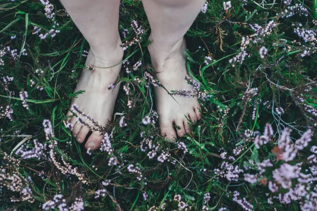 Woman standing in the grass barefoot