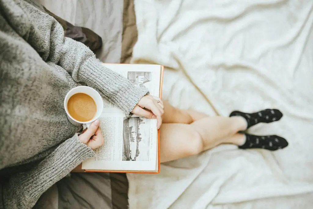 Woman drinking coffee and reading a book