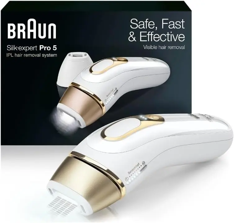 A gold and white Braun laser hair removal system sits against a white background. It's in front of the black box it comes in.