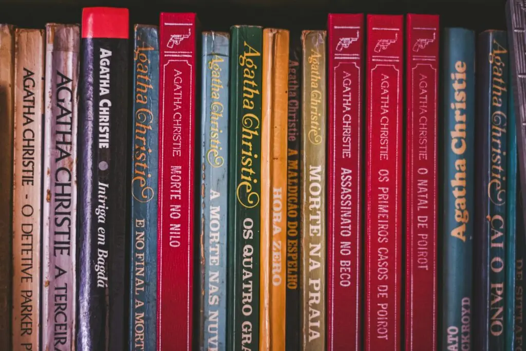 A bookshelf full of Agatha Christie novels in various colors.