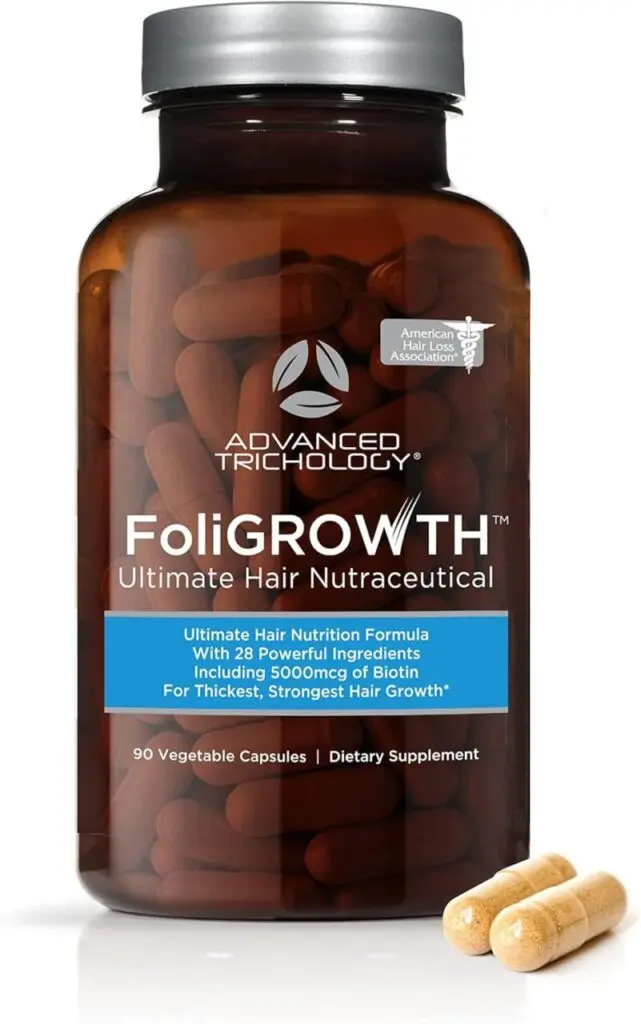 A brown bottle of FoliGROWTH supplements for that are good for hair growth sits against a white background. Two light yellow or light brown capsules sit in front of it on the right side.