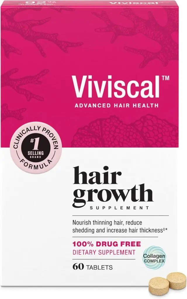 A white and pink box of Viviscal hair growth supplements sits against a white background. Two small brown round tablets sits in front of it on the right side.