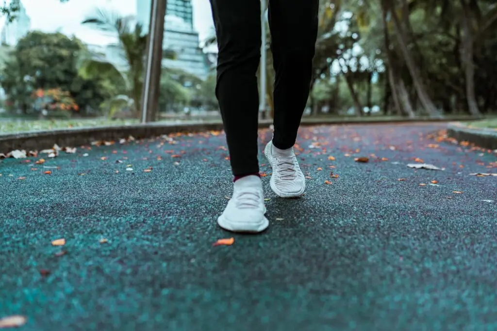 Workout shoes pictured on asphalt with fall leaves in the background