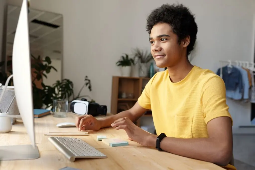 A teenage boy sitting at a computer