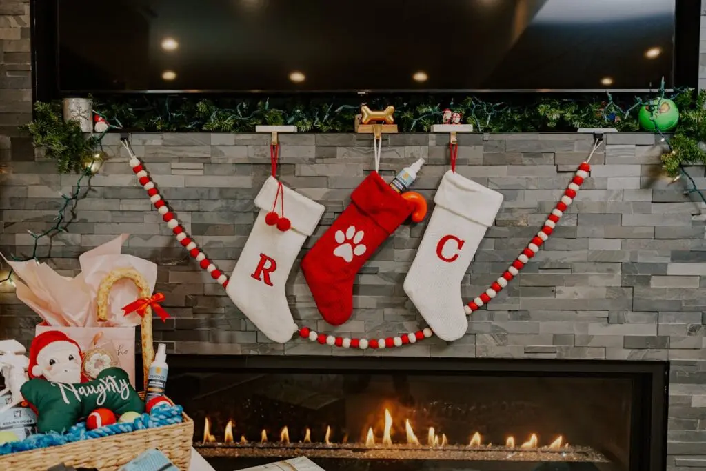 Red and white Christmas stockings hanging above a fireplace