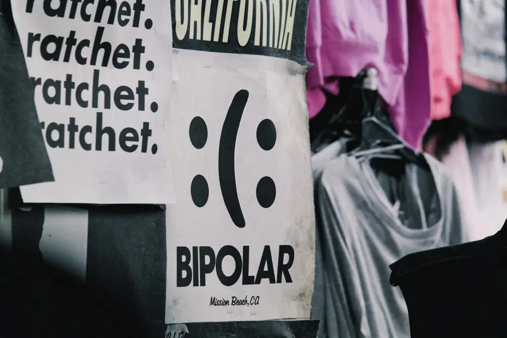 A white sign with a black bipolar symbol