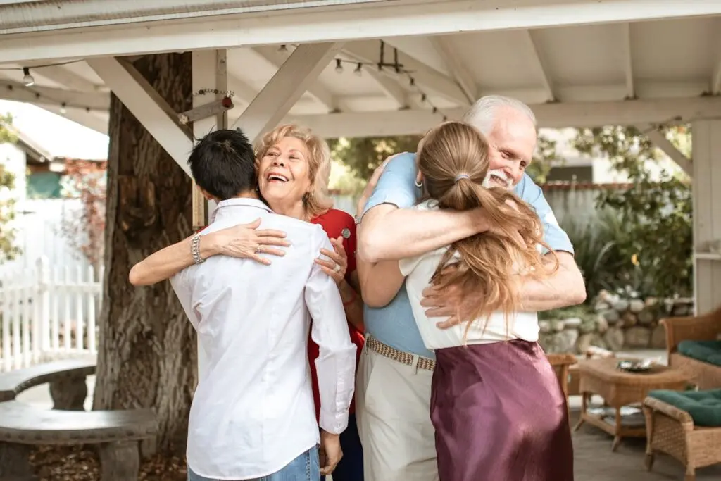 A couple hugging their elderly parents