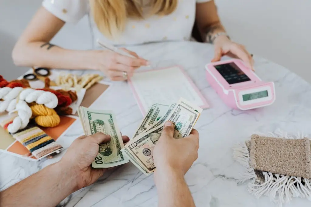 A woman calculating financial debt with a pink calculator