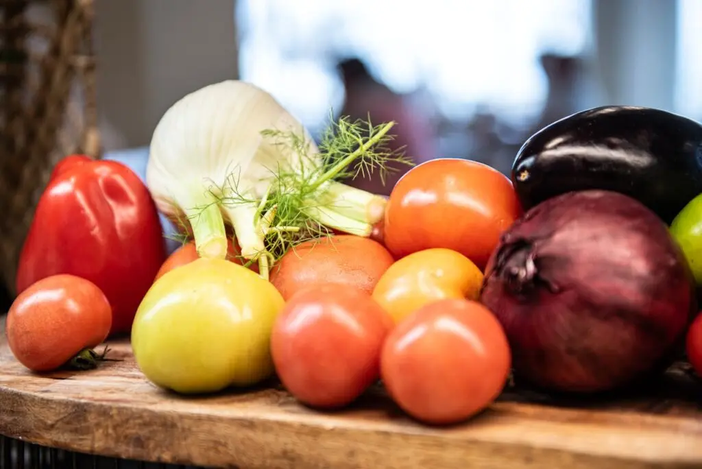 An assortment of fresh vegetables on a wooden surface