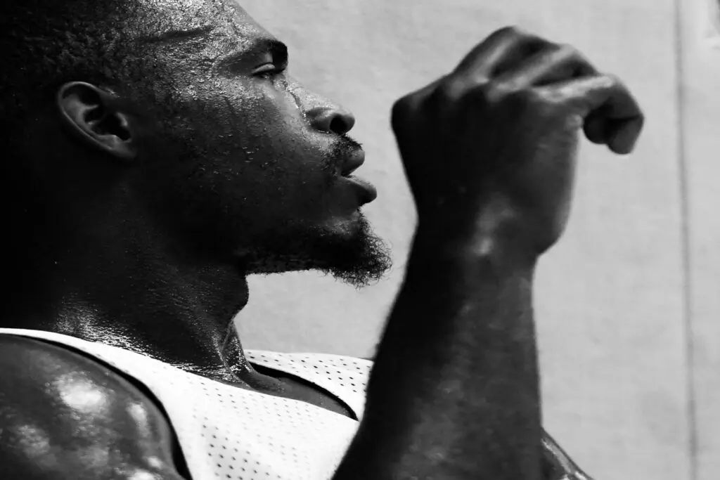 grayscale photo of man in tank top experiencing hot flashes in men