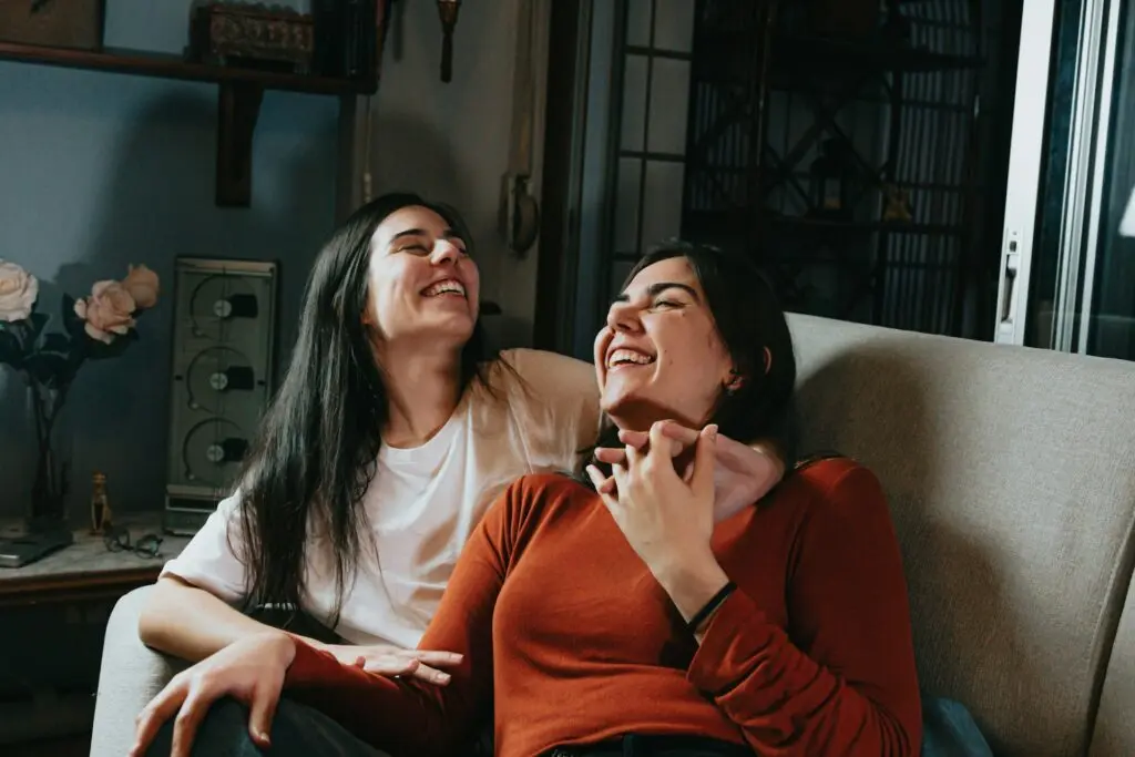 Two Women Laughing on a Couch