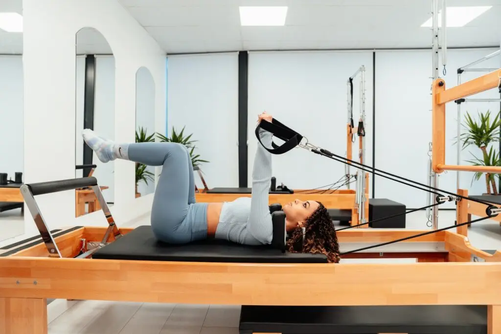 A girl on a reformer in a solidcore class.