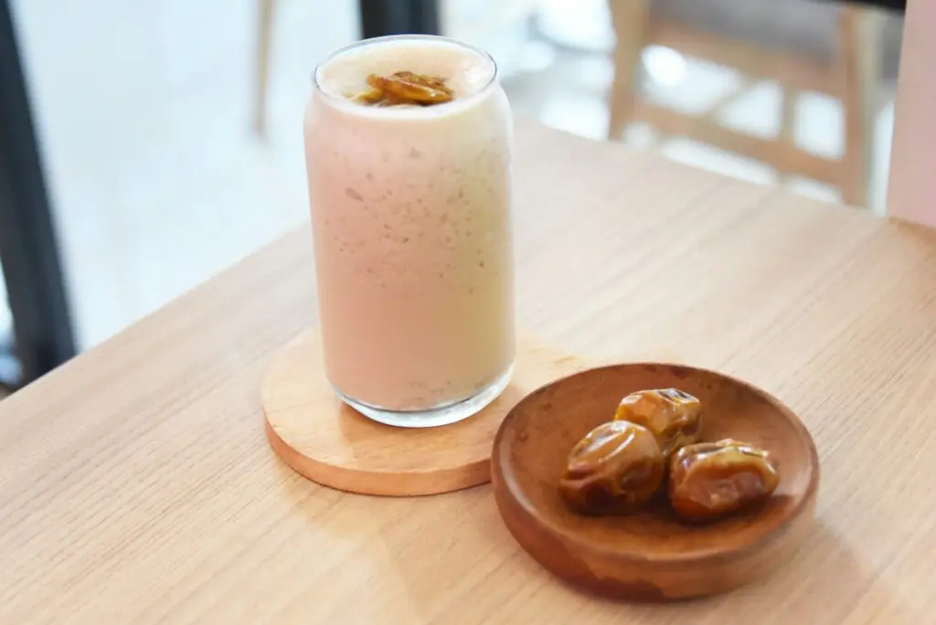 Smoothie on a table with dates.