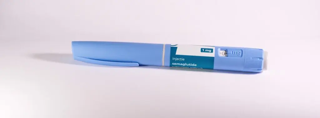 An unused injector pen of semaglutide sits on a white tabletop. It's one of the leading weight loss drugs.