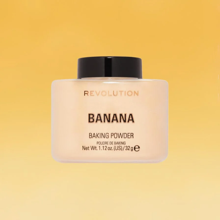 A tan and black container of Revolution's Banana Baking Powder sits against the yellow Body+Mind background.