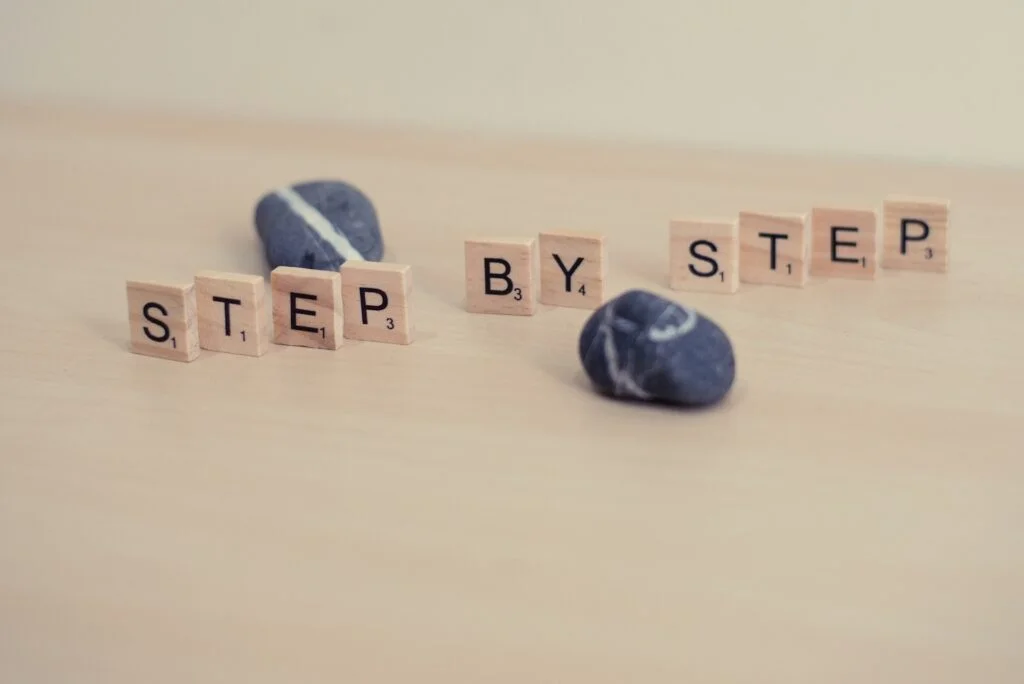 Step by step written using Scrabble tiles.