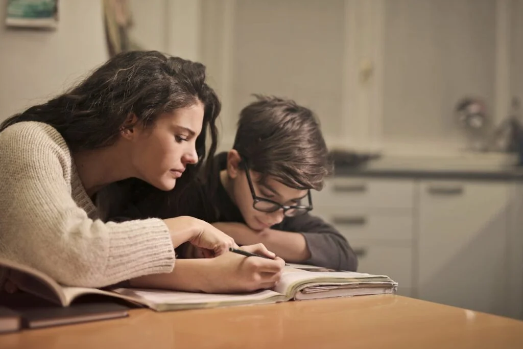 A mother teaching her teen about budgeting at the kitchen table