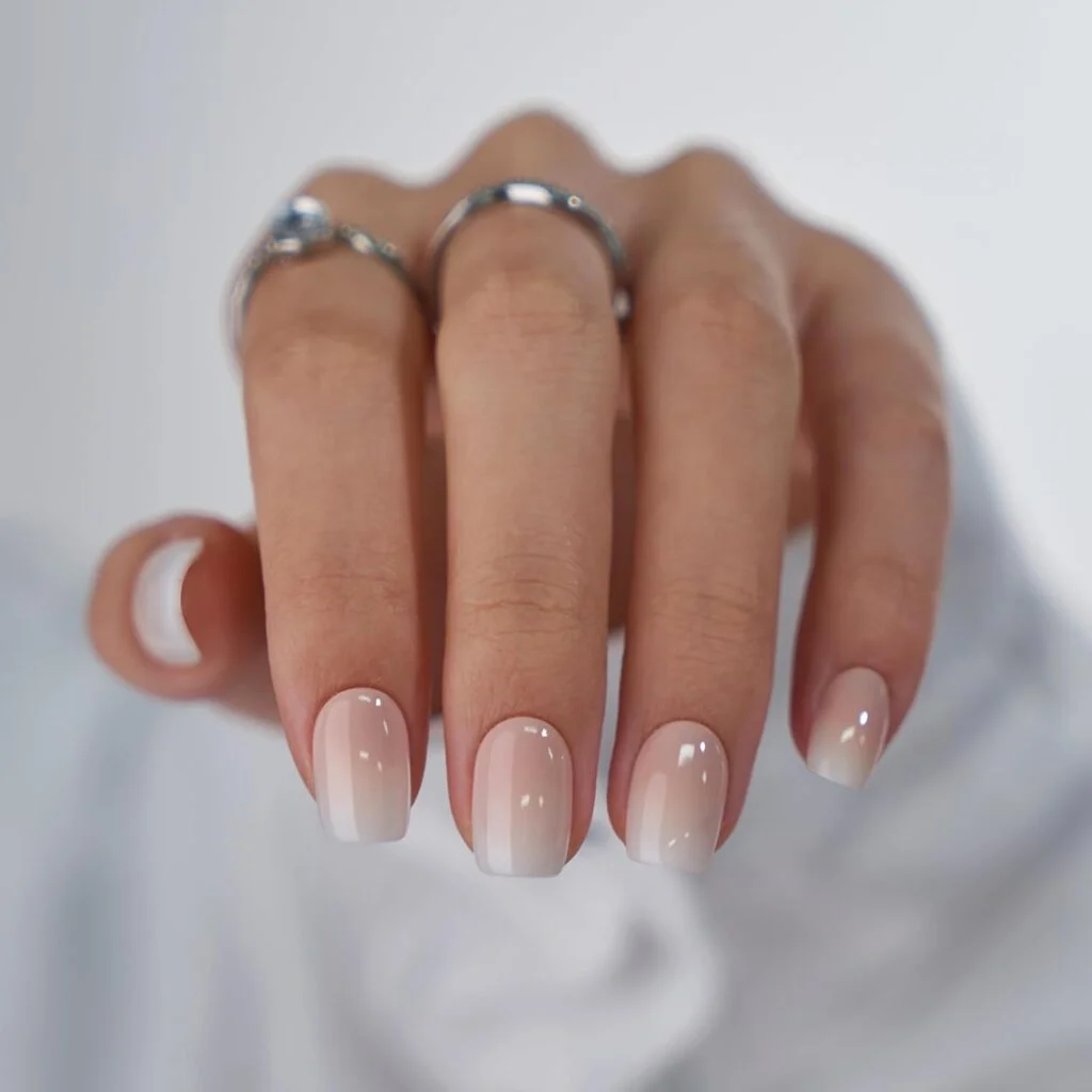 A woman wears a pair of BTArtbox square press-on nails with two silver rings.