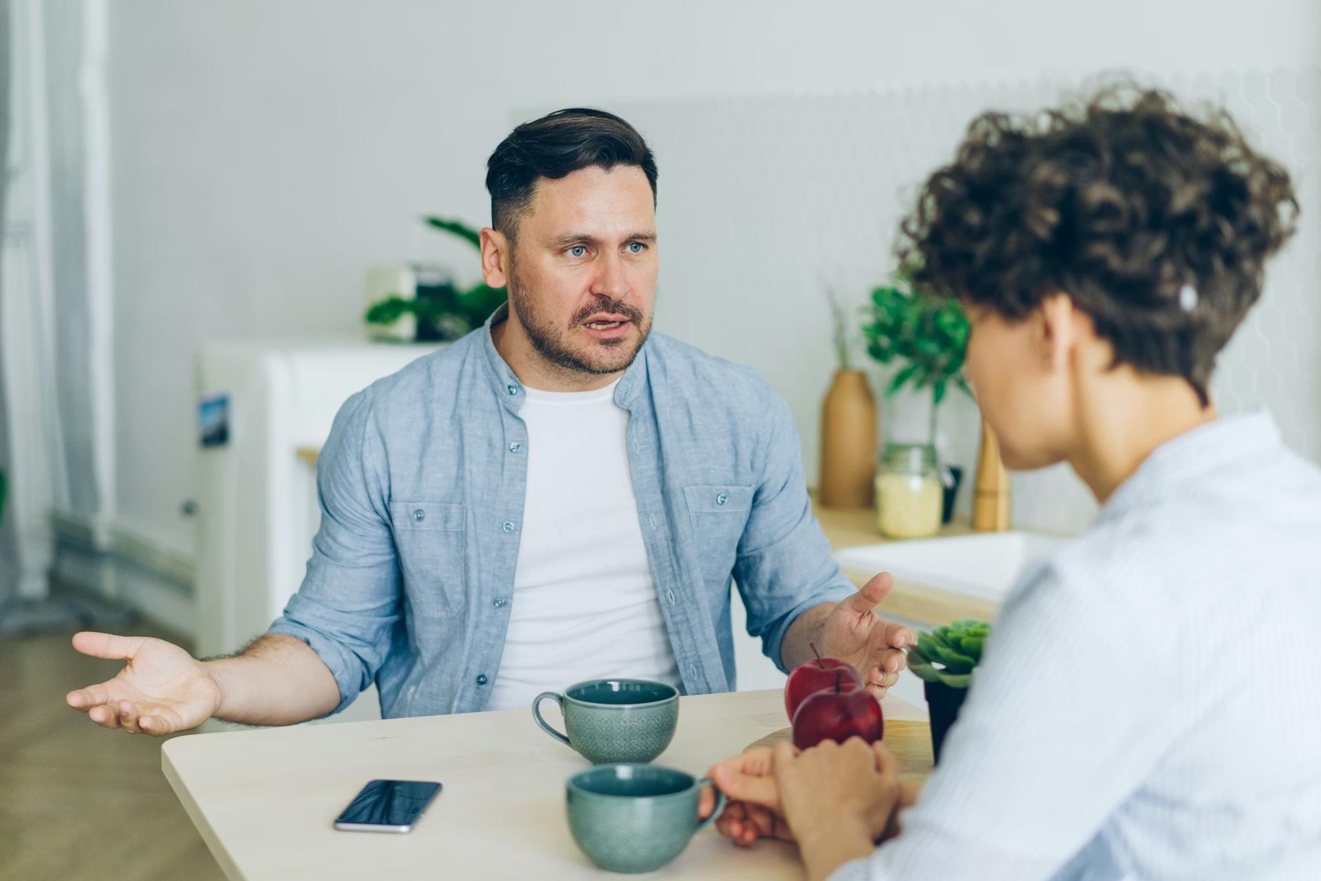 Man in blue shirt arguing with black-haired woman