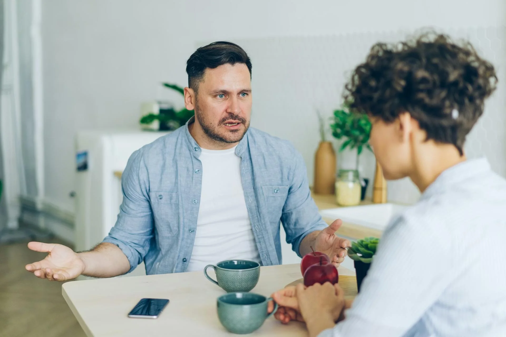 Man in blue shirt arguing with black-haired woman