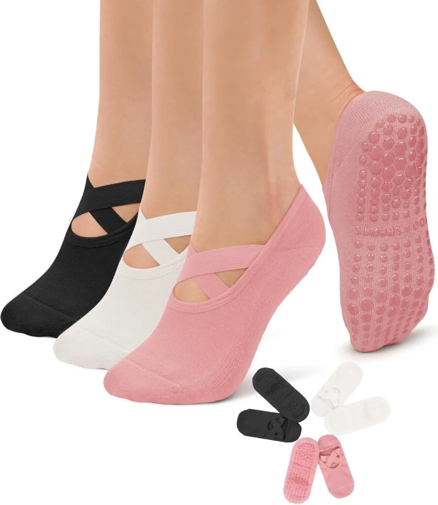 Three women stand on their tip toes while wearing white, pink and black grippy socks. The three pairs line up in a circle underneath their feet.