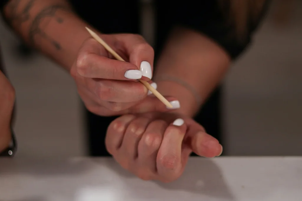 A person pushing back their cuticles