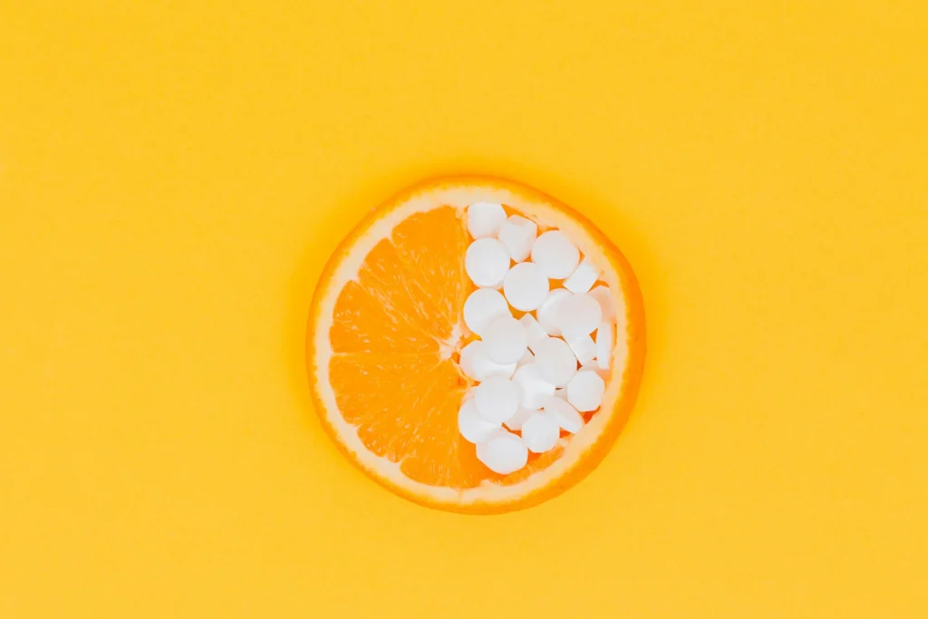 An orange and vitamins to represent vitamin C.