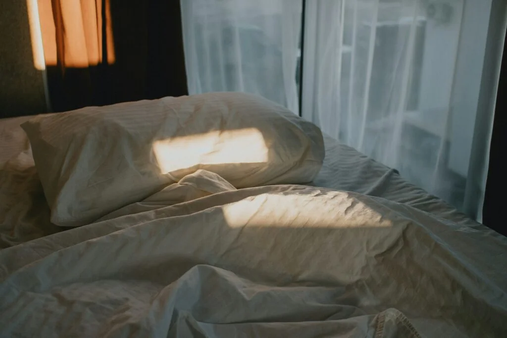 Messy bed near a window