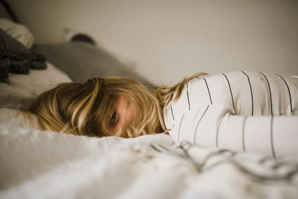Woman lying face-down in a bed