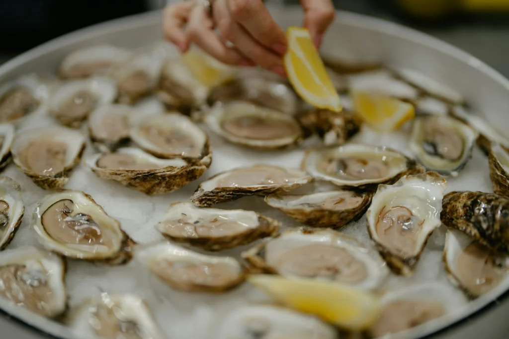 fresh oysters on ice with lemon wedges, an aphrodisiac