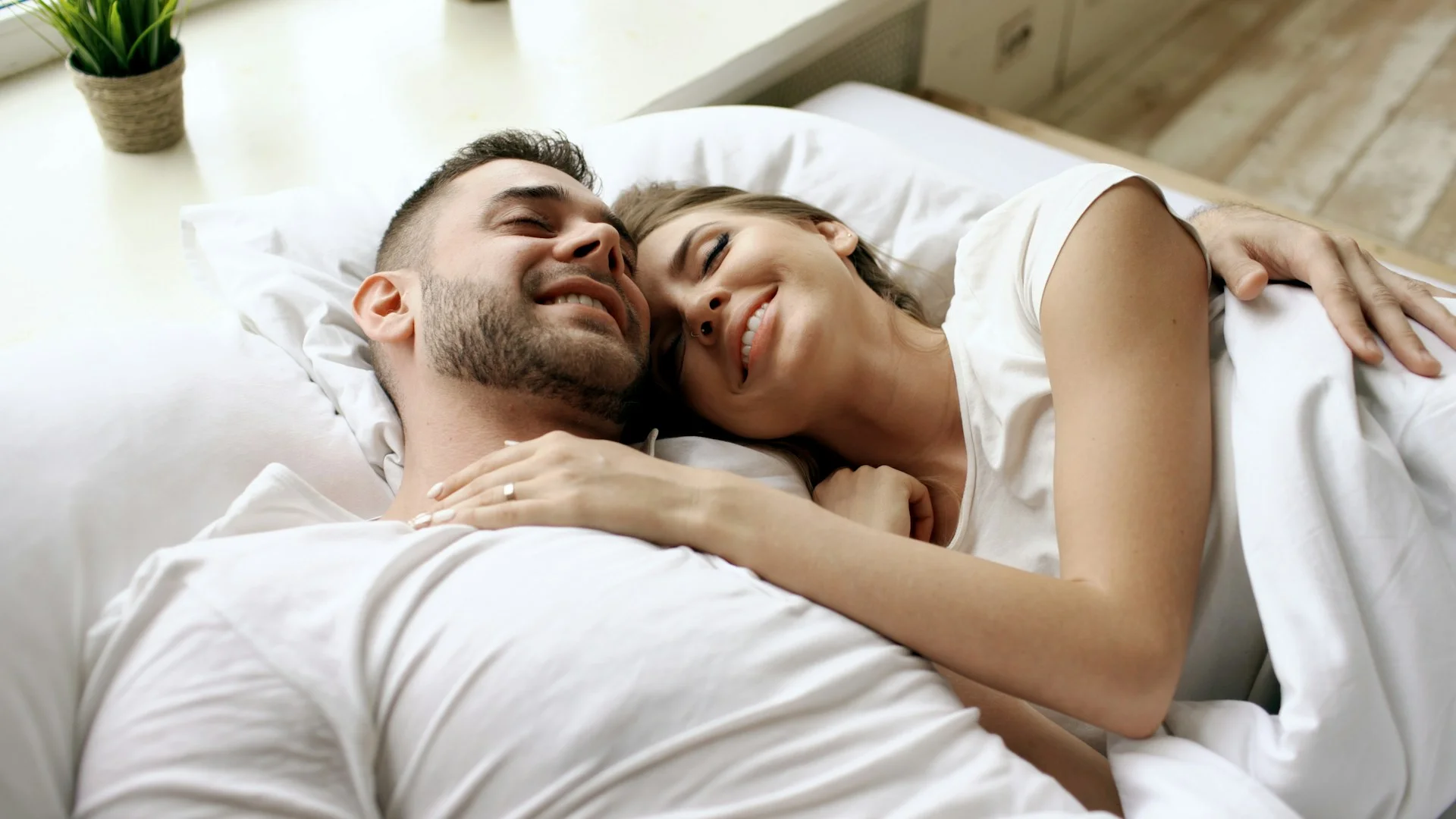 Couple cuddling in bed with eyes closed, a great way on how to increase sex drive