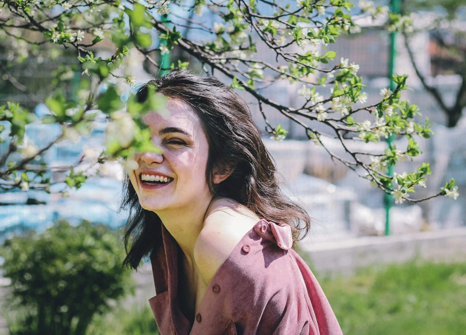 A woman in pink shirt smiling, looking youthful, which is one of the things collagen supplements promise