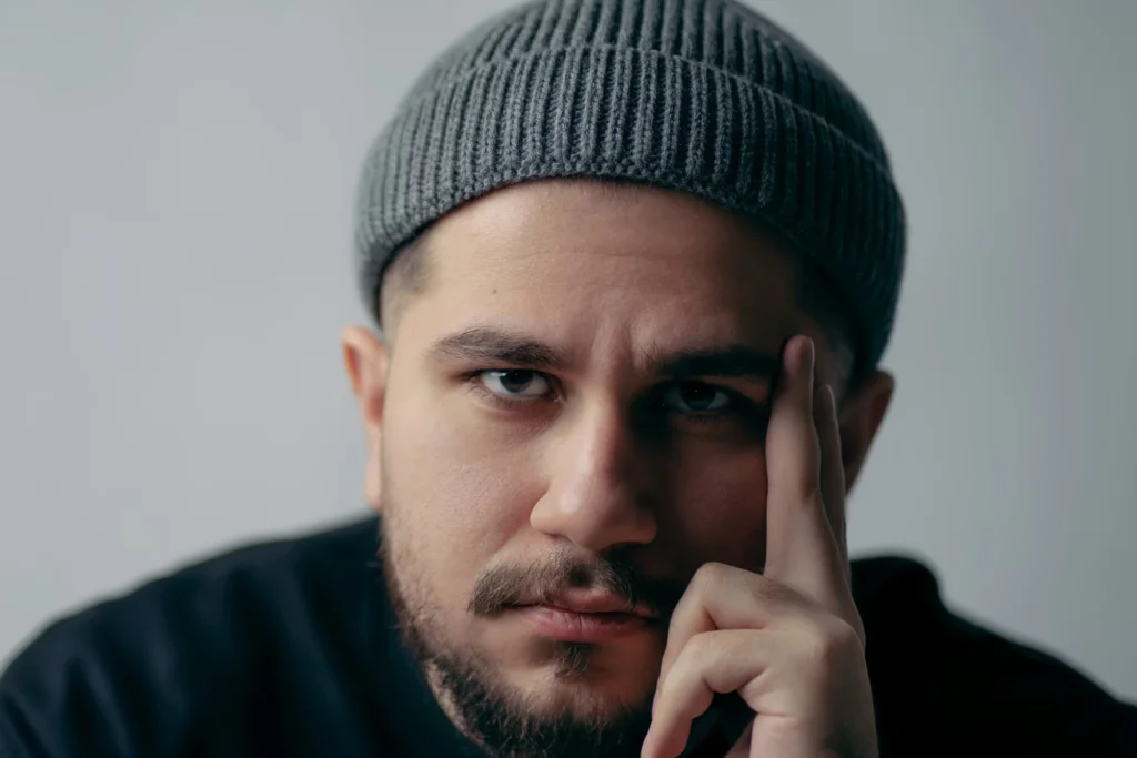 Man in black with gray beanie looking into camera