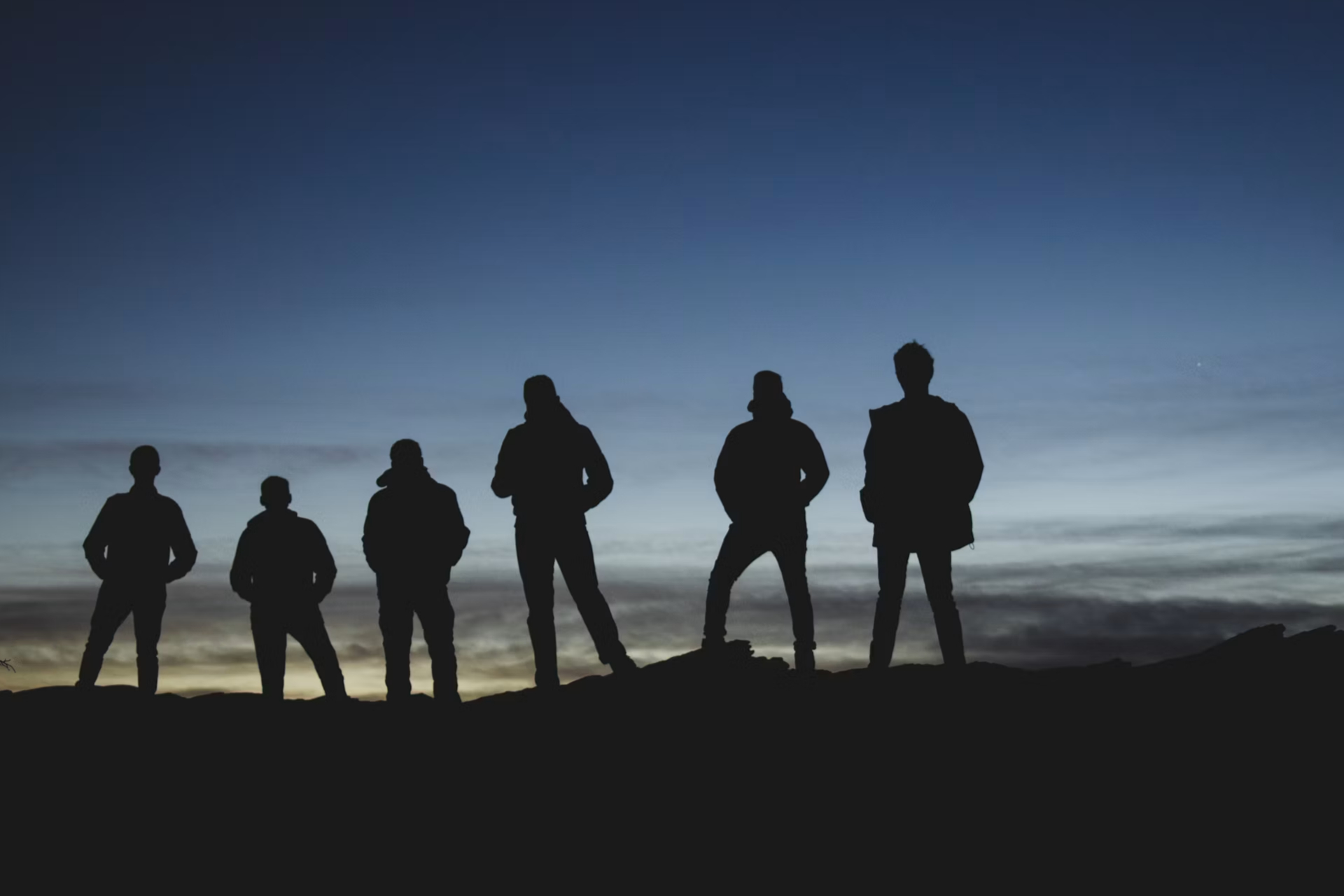 different black silhouettes on hilltop