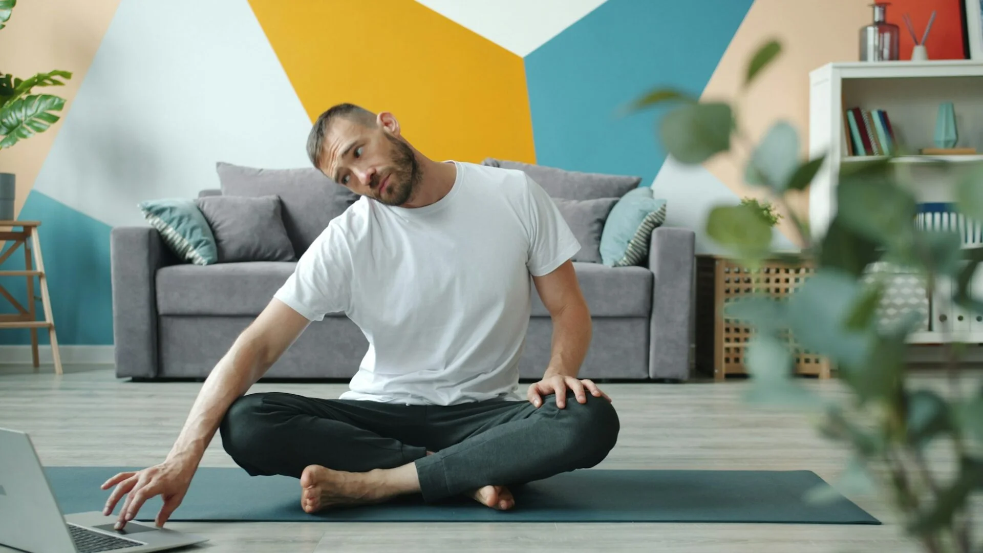 man stretching his neck on a yoga mat