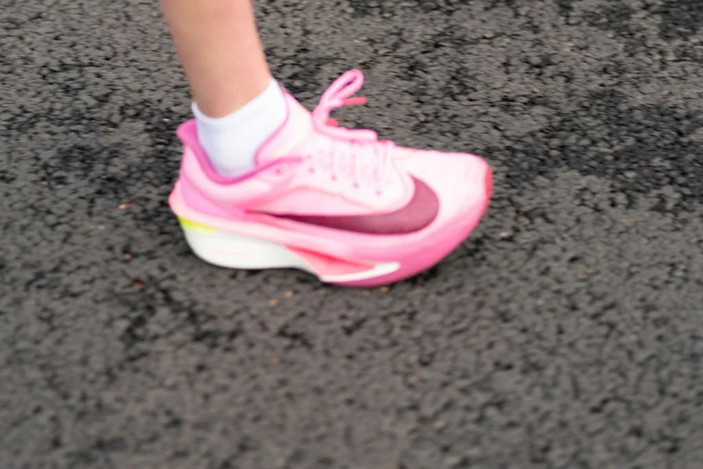A running influencer wearing a pink shoe.