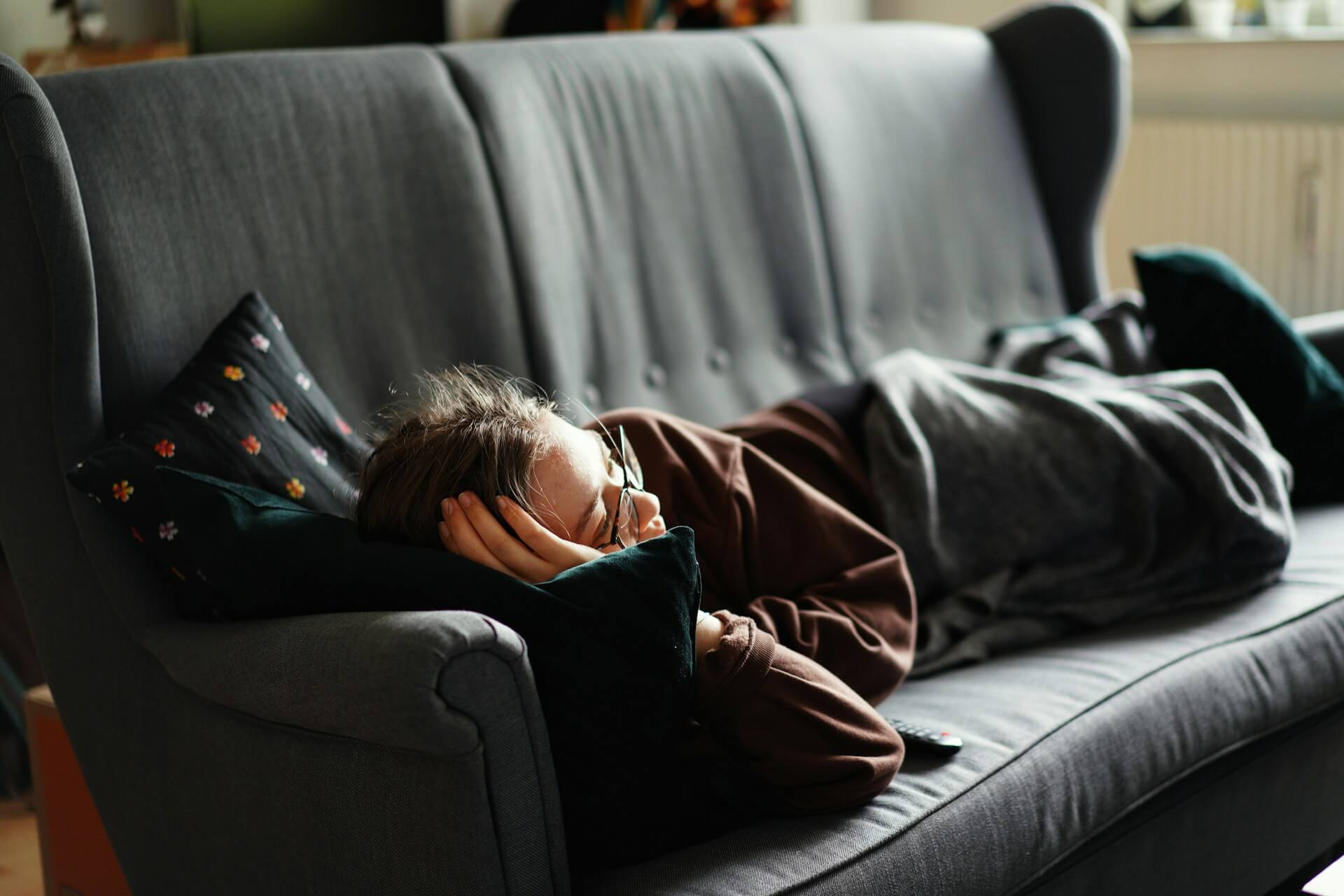 A woman lying relaxed on a gray couch