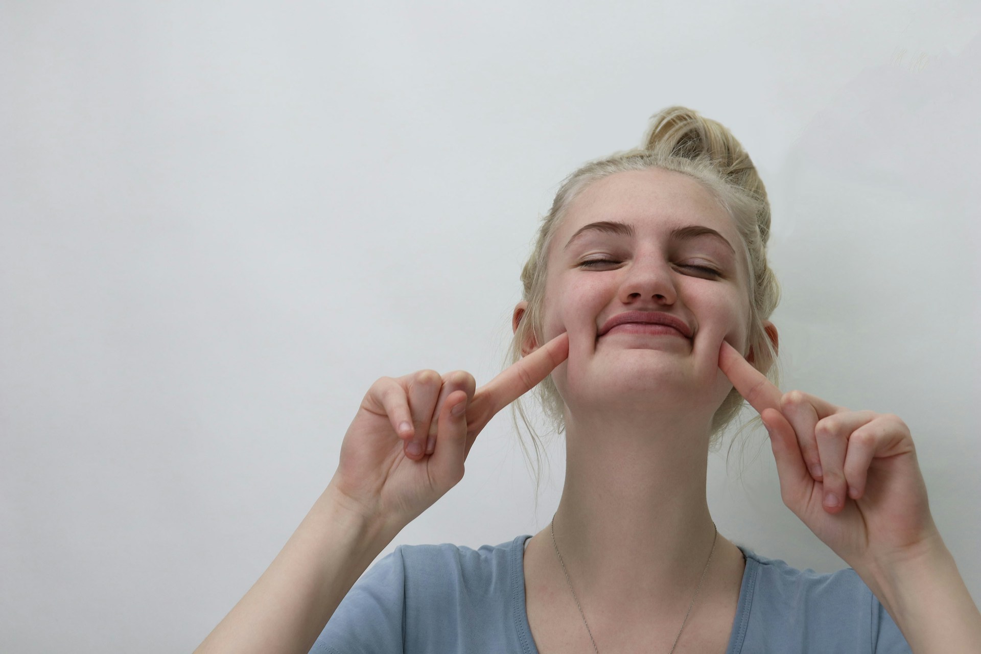 Woman stretching her cheeks with fingers