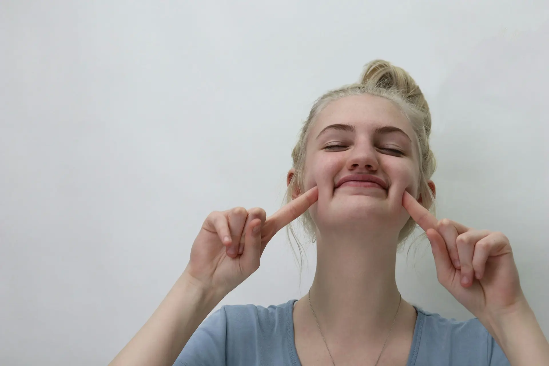 Woman stretching her cheeks with fingers
