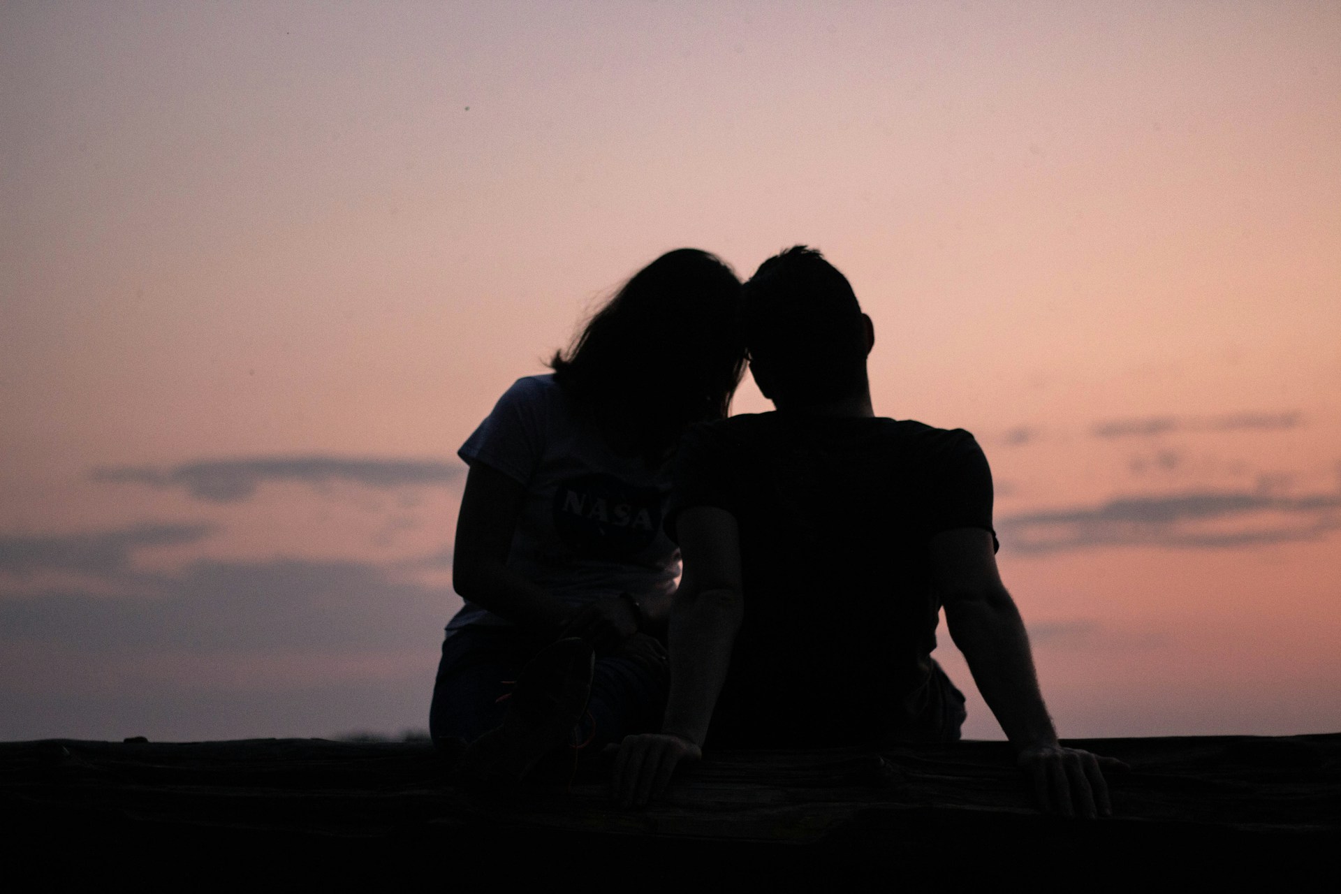 man and woman silhouettes in front of the sky