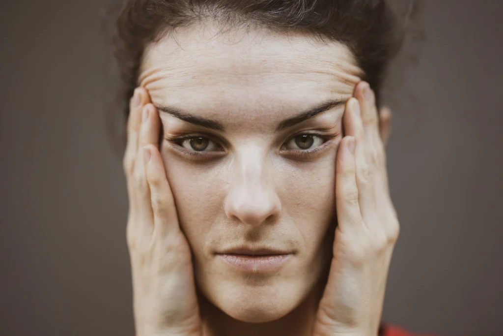 Woman lifting her brow with fingers