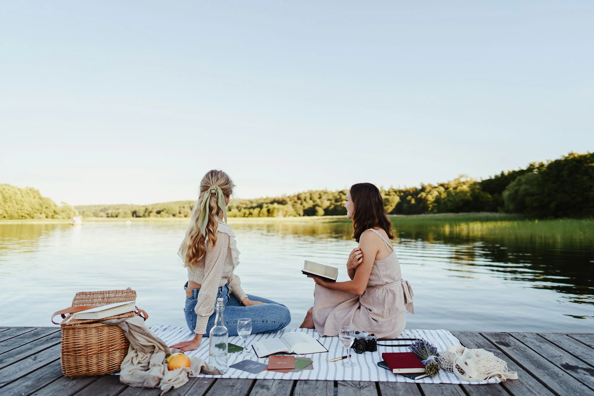Two woman on a picnic by the lake as a fun summer date idea